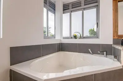 a large white tub in a bathroom with windows at Villa Mustique - Perfect tropical paradise in El Limón