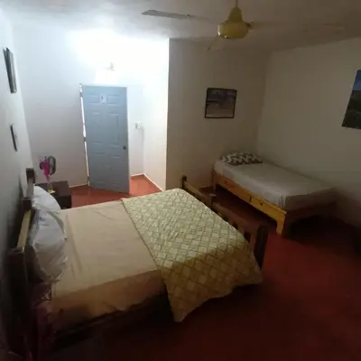 a hotel room with two beds and a door at El jardín del coco in Las Galeras