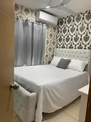 a white bed in a bedroom with a curtain at Casa Mamá Tere in Pantoja