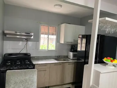 a kitchen with a stove and a black refrigerator at Casa Mamá Tere in Pantoja
