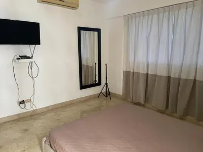 a bedroom with a bed and a television and a window at Amplio y acogedor apto céntrico de 3 habitaciones in Santo Domingo