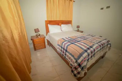 a bedroom with a bed with a plaid comforter at JARABACOA villa Almonte in Jarabacoa