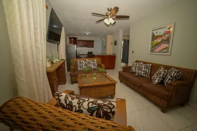 a living room with two couches and a kitchen at JARABACOA villa Almonte in Jarabacoa