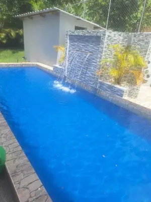a blue swimming pool with a fence around it at JARABACOA villa Almonte in Jarabacoa