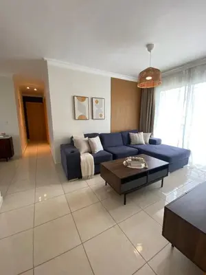 a living room with a blue couch and a coffee table at Apartamento acogedor con estilo y piscina in La Romana