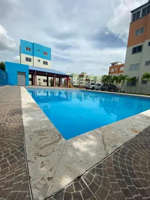 a large blue swimming pool in front of a building at Apartamento acogedor con estilo y piscina in La Romana
