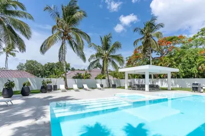 a swimming pool with a gazebo and palm trees at Casa Deco in La Romana