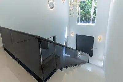 a staircase with a glass rail and a window at Casa Deco in La Romana