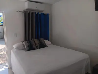 a bedroom with a bed with a blue curtain at Hospedaje Las Flores Pedernales in Pedernales