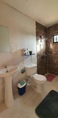 a bathroom with a toilet and a sink at Hospedaje Las Flores Pedernales in Pedernales