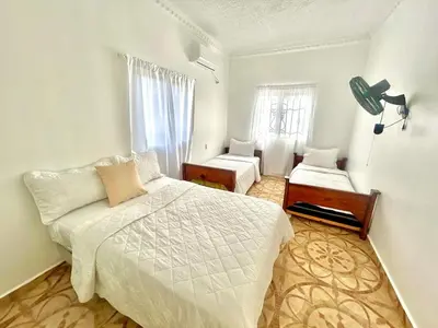a white bedroom with a bed and a window at Villa Rosa 3 Habitaciones Balcones Aire Acondicionado Espacio Ideal Para Tu Familia O Grupo in Río San Juan