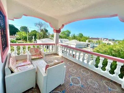 a balcony with white chairs and a balcony railing at Villa Rosa 3 Habitaciones Balcones Aire Acondicionado Espacio Ideal Para Tu Familia O Grupo in Río San Juan