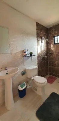 a bathroom with a toilet and a sink at Hospedaje Las Flores Pedernales in Pedernales