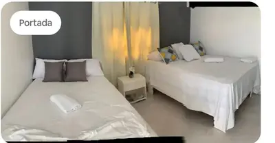 two beds sitting next to each other in a room at Hospedaje Las Flores in Pedernales