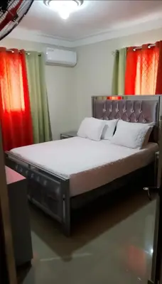 a bed in a room with red and green curtains at Hermoso apartamento 3 habitaciones in Los Paredones