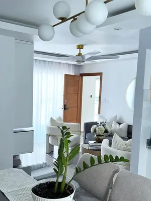 a living room with white furniture and a ceiling fan at Family-friendly apartment near the beach in Boca Chica