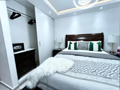 a bedroom with a bed with a white blanket and a mirror at Family-friendly apartment near the beach in Boca Chica