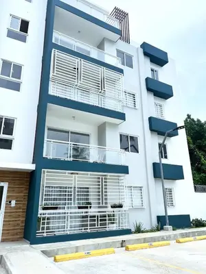 a white building with balconies and an american flag at Family-friendly apartment near the beach in Boca Chica