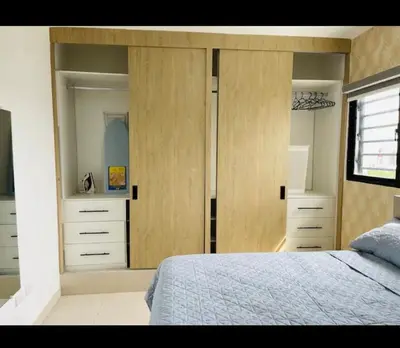 a bedroom with a bed and wooden cabinets at Residencial JT1 Avenida España in La Viva