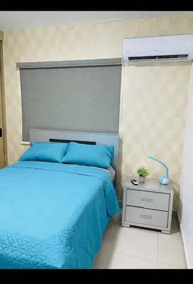 a bedroom with a blue bed and a night stand at Residencial JT1 Avenida España in La Viva