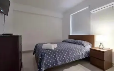 a bedroom with a bed and a dresser with a mirror at Encanto en gazcue - Cerca del Malecón y la Zona Colonial in Santo Domingo