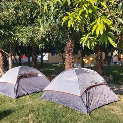 two tents sitting in the grass under trees at Terrenal Paradise in Esperanza