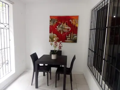 a dining room with a black table and chairs at SML Garden Apartament in La Romana