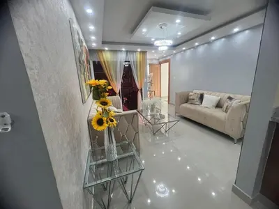 a living room with a couch and a table with flowers at Moderno y amplio apartamento en Santiago in Carlos Guerra