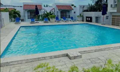 a large swimming pool with blue chairs in front of a building at Boca Chica in Boca Chica