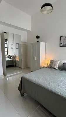 a white bedroom with a bed and a mirror at Soho loft residence in Santo Domingo