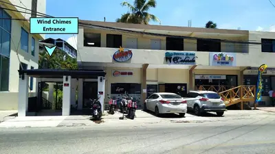 a building with cars parked in front of it at Cabarete Heartbeat Suite, 1 BR in Cabarete