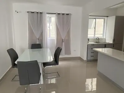 a white dining room with a table and chairs at Cozy Tropical Getaway in Los Altos de Jalisco