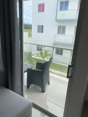 a room with a chair on a balcony with a window at Cozy Tropical Getaway in Los Altos de Jalisco