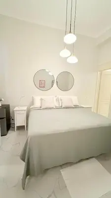 a white bedroom with a large bed and two mirrors at Exclusive Soho Loft Residence in Santo Domingo