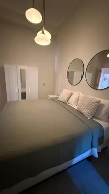 a bedroom with a large bed with two mirrors at Exclusive Soho Loft Residence in Santo Domingo