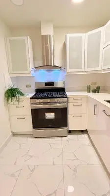 a kitchen with a stove and white cabinets at Exclusive Soho Loft Residence in Santo Domingo