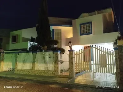 a white fence in front of a house at night at Casa Oasis in Juan López