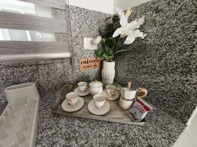 a tray with cups and plates and a vase with flowers at Apartamento Cómodo en Punta Cana in Punta Cana