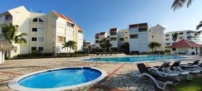 a resort with a swimming pool and chairs and buildings at Vista marina apartment in Villas del Mar