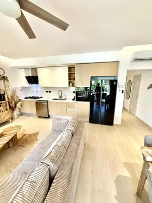 a living room with a couch and a kitchen at Tropical Escape with 3 Pools & Private Beach Club Aqua Esmeralda in La Laguna