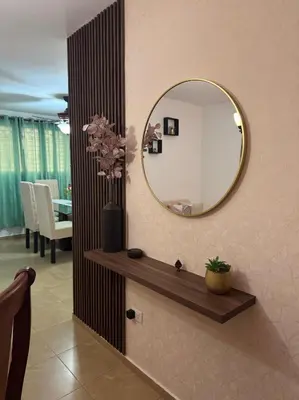 a bathroom with a mirror and a vase with flowers at Acogedor y céntrico apartamento en Palmas de Gurabo in Santiago de los Caballeros