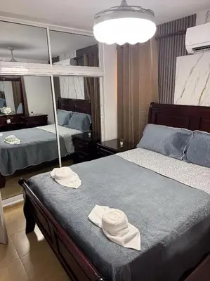 two beds in a bedroom with two hats on top at Acogedor y céntrico apartamento en Palmas de Gurabo in Santiago de los Caballeros