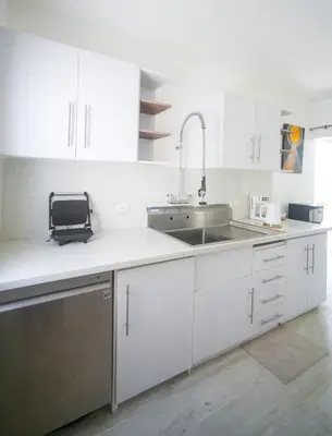 a kitchen with white cabinets and a sink at La casa del Maestro apartment in Bayahibe