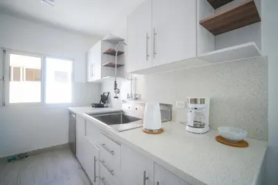 a kitchen with white cabinets and a counter with a mixer at La casa del Maestro apartment in Bayahibe
