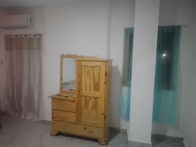 a wooden dresser with a mirror in a room at Home Realty in Santo Domingo