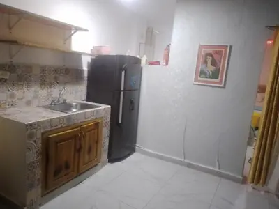 a kitchen with a black refrigerator and a sink at Home Realty in Santo Domingo