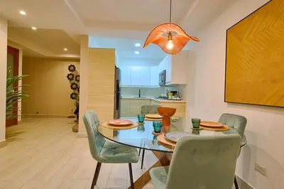 a dining room with a glass table and chairs at ®{Tulum~Experience}@Downtown PoolViewPenthouse in Santo Domingo