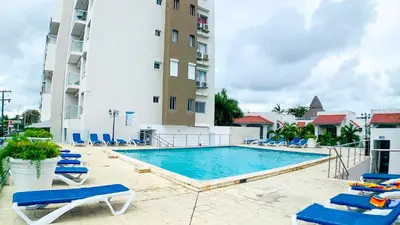 a swimming pool with lounge chairs and a building at Apartamento en Boca Chica T1 302 in Boca Chica