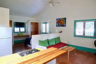 a living room with a couch and a refrigerator at Apart-Hotel Garden Villa in Las Galeras