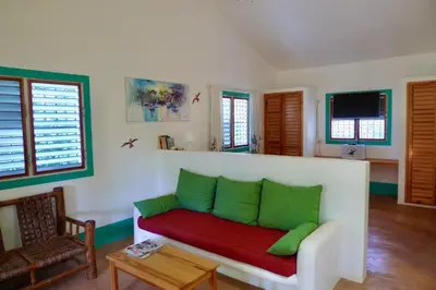 a living room with a red and green couch at Apart-Hotel Garden Villa in Las Galeras